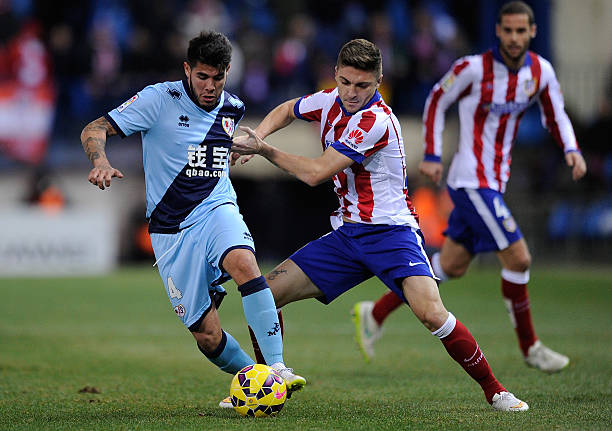 MADRID, SPAIN - JANUARY 24: Alejandro Pozuelo of Rayo Vallecano de Madrid is tackled by Jose Gimenez of Club Atletico de Madrid during the La Liga match between Club Atletico de Madrid and Rayo Vallecano de Madrid at Vicente Calderon Stadium on January 24, 2015 in Madrid, Spain.