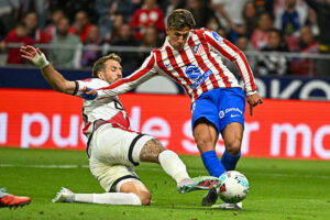 TOPSHOT - Atletico Madrid's Argentine forward #20 Giuliano Simeone (R) is challenged by Rayo Vallecano's French defender #24 Florian Lejeune during the Spanish league football match between Club Atletico de Madrid and Rayo Vallecano de Madrid at the Metropolitano stadium in Madrid on September 24, 2025. (Photo by Javier SORIANO / AFP) (Photo by JAVIER SORIANO/AFP via Getty Images)