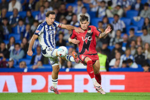 SAN SEBASTIAN, SPAIN - OCTOBER 05: Mikel Oyarzabal of Real Sociedad competes for the ball with Andrei Ratiu of Rayo Vallecano during the LaLiga EA Sports match between Real Sociedad and Rayo Vallecano at Anoeta on October 5, 2025, in San Sebastian, Spain. (Photo By Ricardo Larreina/Europa Press via Getty Images)