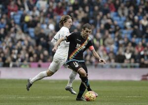 MADRID, SPAIN - DECEMBER 20: Luka Modric of Real Madrid in action against Roberto Trashorras (R) of Rayo Vallecano during the La Liga match between Real Madrid CF and Rayo Vallecano at Estadio Santiago Bernabeu on December 20, 2015 in Madrid, Spain. (Photo by Burak Akbulut/Anadolu Agency/Getty Images)