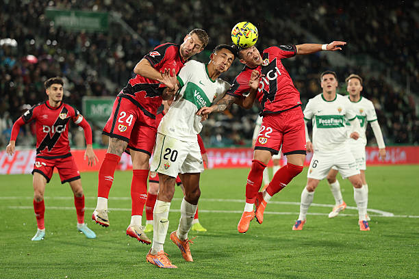 ELCHE, SPAIN - DECEMBER 21: Alvaro Rodriguez of Elche CF jumps for the ball with Florian Lejeune and Alfonso Espino of Rayo Vallecano during the LaLiga EA Sports match between Elche CF and Rayo Vallecano de Madrid at Estadio Manuel Martinez Valero on December 21, 2025 in Elche, Spain. (Photo by Clive Brunskill/Getty Images)